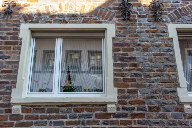 Ortaçağ dış duvarında perdeleri olan beyaz ahşap bir pencerenin doku arka planını kapat.