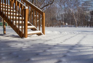 Bu resim, kış aylarında sedir ağacından bir güvertede taze kar tasarımlarının tam bir çerçeve soyut dokusunu ve doğal güneş ışığını gösteriyor..