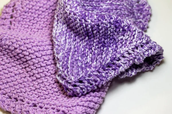 Bu resim, mor ve beyaz tonlarında, jartiyer dikişinde el örgüsü iplik kumaşının makro soyut bir arkaplanını gösteriyor..