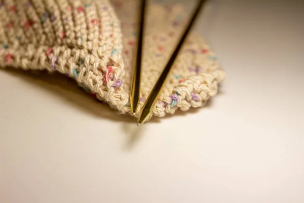 この画像は 白い背景に手編みの綿布と金属編みの針のペアのクローズアップビューを示しています コピースペースと — ストック写真