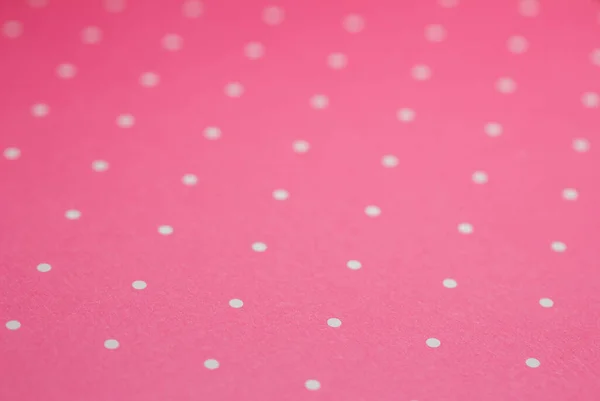Full frame abstract texture background of solid pink and white polka dots pattern with selective focus
