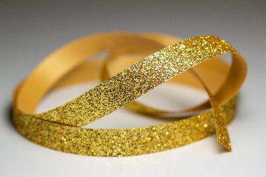Full frame macro abstract texture background of sparkling gold color Christmas holiday fabric glitter ribbon with bokeh and copy space