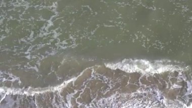 Kumlu bir sahil manzarası, kıyıya vuran deniz dalgaları, deniz köpüğü. Güzel bir video, rahatlama. Deniz manzarası, fırtınalı Karadeniz..