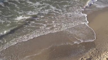  Kumlu bir sahil manzarası, kıyıya vuran deniz dalgaları, deniz köpüğü. Güzel bir video, rahatlama. Deniz manzarası, fırtınalı Karadeniz..