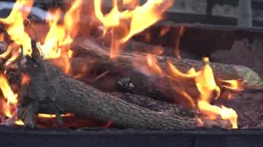Kamp ateşi, odun, kömür ve kül gibi yakın çekim alevleri. Yaz akşamında barbekü için yangın. Güzel doğal video 4K. Yakın çekim şenlik ateşi.