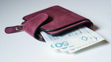 Mor bir cüzdanın yakın çekimi, beyaz arka planda zloti banknotları, Polonya parası. Başka bir ülkede döviz kuru kavramı. Seçici odak