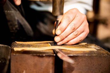 Bir demirci, Japon katana samuray kılıcının metal bir kılıcına çekiç ve küçük bir çivi kullanarak isim kazıyor.. 