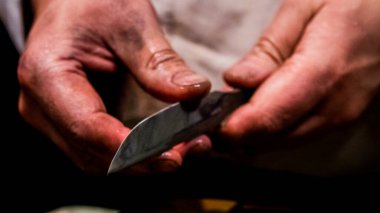 Kılıç ustası küçük katana kılıcının keskinliğini kontrol ediyor.