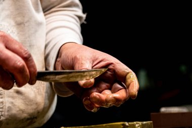 Kılıç ustası küçük katana kılıcının keskinliğini kontrol ediyor.