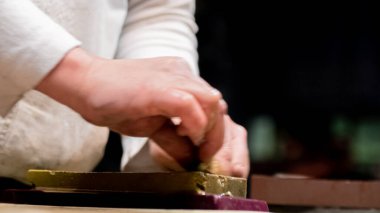 Kılıç ustası küçük katana kılıcının keskinliğini kontrol ediyor.