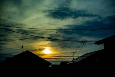 Silhouette of electric cables and towers at sunset time