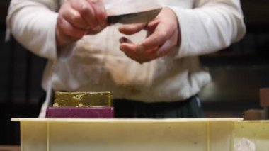 Usta kılıç ustası, bıçağını öğütücüde keskinleştiriyor.