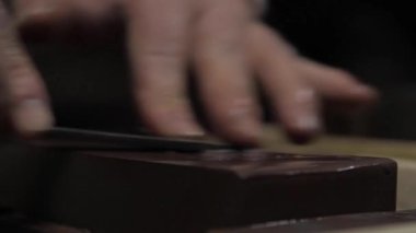 Usta kılıç ustası, bıçağını öğütücüde keskinleştiriyor.