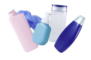 Beyaz arka planda izole bir şekilde havaya düşen plastik bir şişe. Vücut bakımı ürünü, şampuan, jel banyosu, sünger.