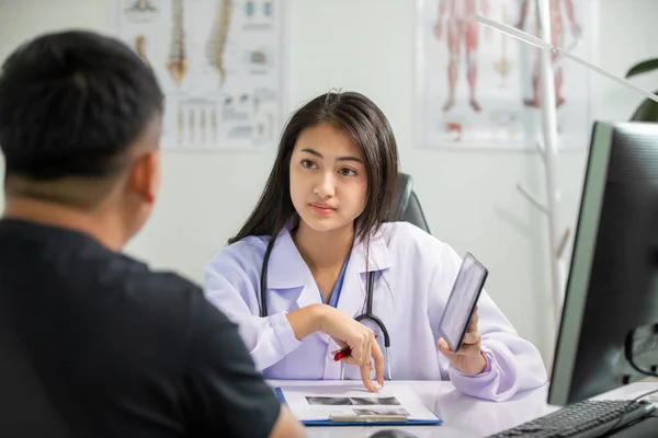 Asyalı Kadın Doktor Erkek Hasta Klinikte Röntgen Görüntüleri Hakkında Tartışıyorlar — Stok fotoğraf