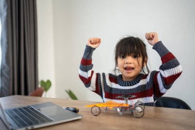 Asyalı kızlar elektrikli robot araba yapmayı ve tamir etmeyi ve çevrimiçi eğitim kursunu öğrenmeyi seviyorlar ve mutluluk ve başarı için elinizi kaldırın.