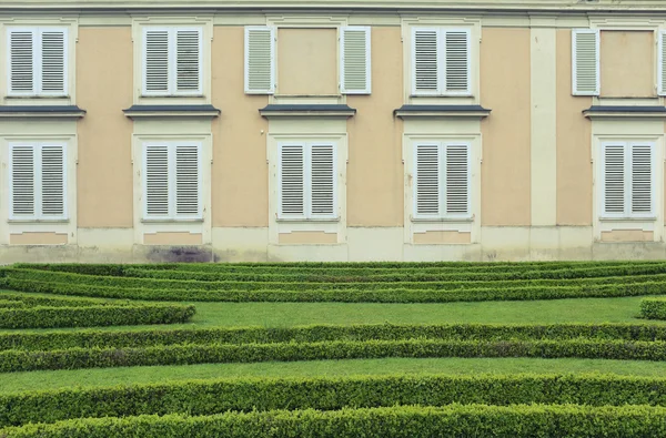 Mur de construction avec fenêtres près de la pelouse — Photo