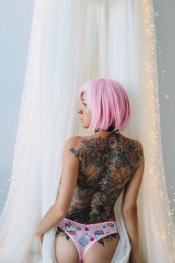 Pembe saçlı, şehvetli, dövmeli bir kadının arka planı.