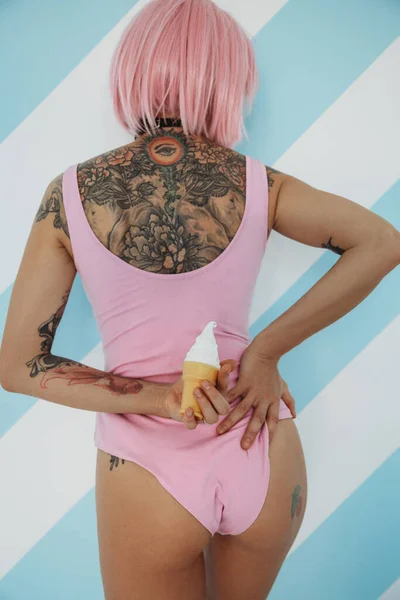带着冰激淋的粉色头发的年轻纹身女子的背影 — 图库照片