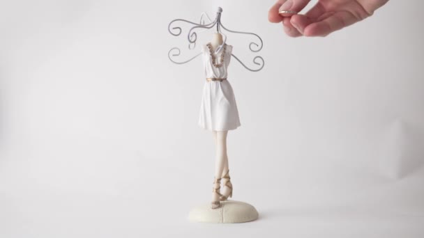 Close-up, The Womans Hand cuelga anillos en un puesto de joyería sobre un fondo blanco — Vídeo de stock