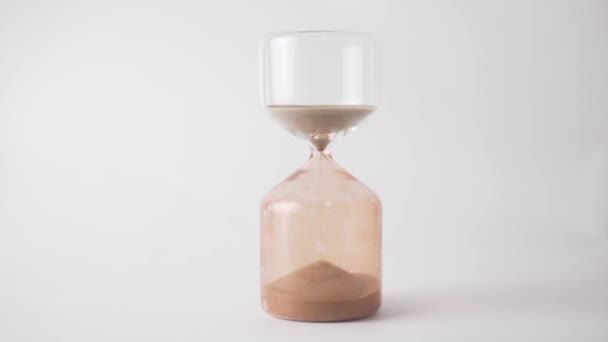 Sanduhr in Großaufnahme für zehn Minuten, Sand ergießt sich auf weißem Hintergrund — Stockvideo