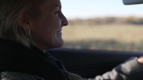 Piękna kobieta prowadząca samochód na tle jesiennych krajobrazów natury — Wideo stockowe