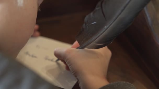 Närbild, skriver en blond pojke ett brev med en penna av bläck — Stockvideo