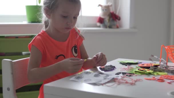 Un niño hace calabazas y arañas con papel para Halloween. — Vídeos de Stock