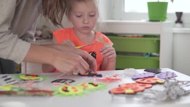 Mamma hjälper sin lilla dotter göra dekorationer för Halloween — Stockvideo