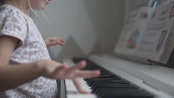 Zblízka, malá holka se naučí hrát na klavír na dětské tóny — Stock video