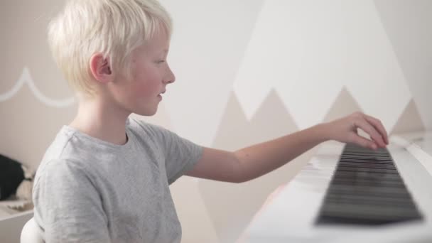 Un hermoso niño brillante no quiere aprender a tocar el piano — Vídeos de Stock