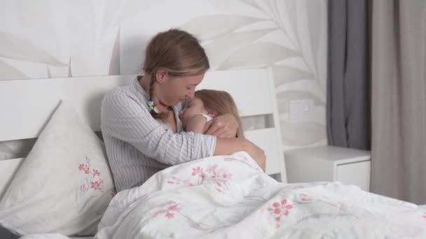 Mãe coloca sua filha na cama durante o dia em sua cama — Vídeo de Stock
