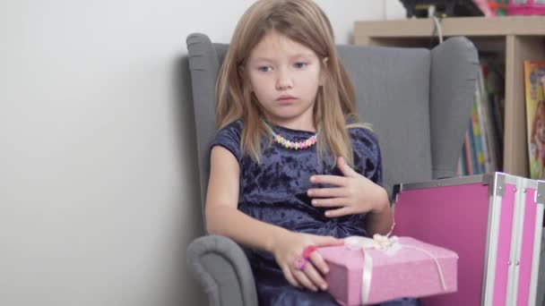 En liten flicka klädde upp sig och samlades för en semester väntar på sin mamma — Stockvideo
