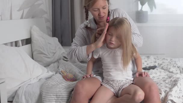 Mãe tranças suas filhas cabelo na parte da manhã na cama — Vídeo de Stock
