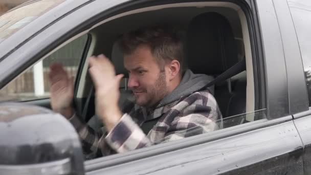 Un uomo dal finestrino di una macchina nera giura e fa gesti nervosi, poi se ne va. — Video Stock