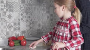 Anne ve kızı mutfakta balık sarması pişiriyor.