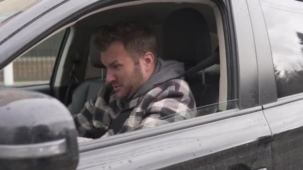 En arg, nervös manlig förare svär och slår ratten i en bil med fönstret öppet. — Stockvideo