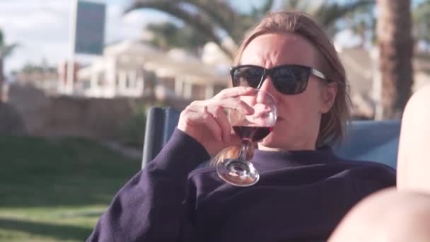 A female tourist in sunglasses drinks wine at a hotel in Egypt in winter — Video Stock