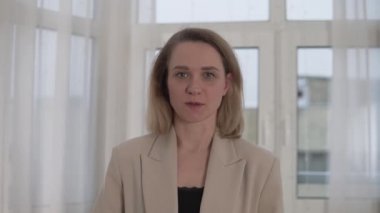 Yakın plan, bir iş kadını kamerada konuşuyor. Şirket hakkındaki rapor başarılı.