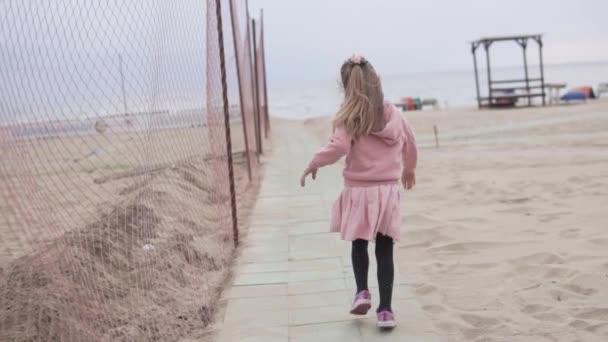 Uma menina corre ao longo do caminho para o mar — Vídeo de Stock