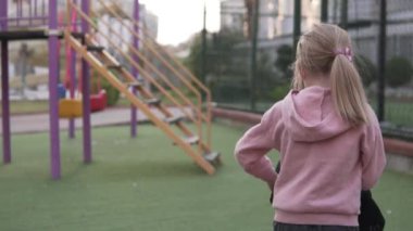 Bir çocuk oyun sahasında pelüş bir oyuncakla oynar..