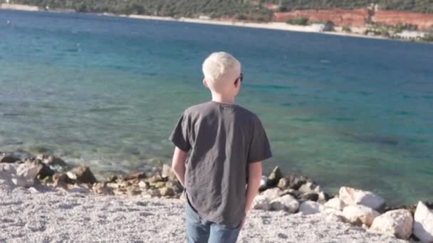 Anak laki-laki pirang berjalan ke laut — Stok Video