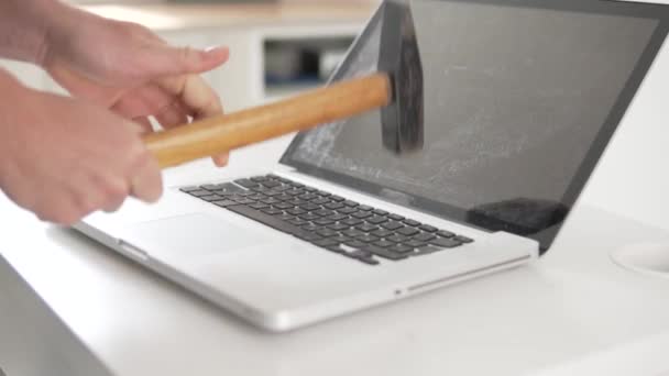 Uma mulher bate o teclado de um laptop quebrado com um martelo — Vídeo de Stock