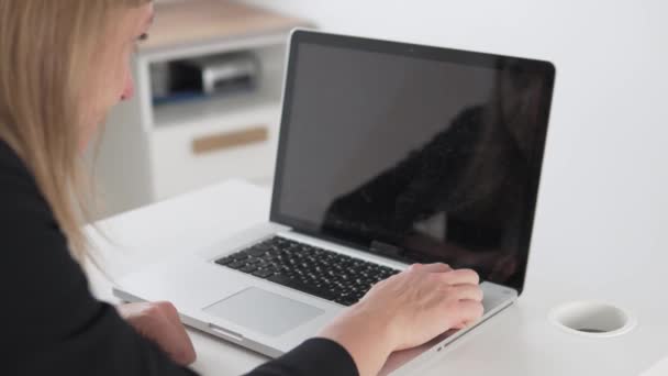 Egy nő beveri az öklét egy törött laptop billentyűzetébe. — Stock videók