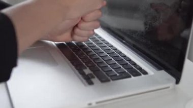 Yakın plan, kadınların yumrukları dizüstü bilgisayara sertçe çarptı.