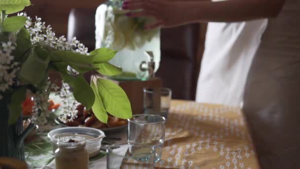 Жінка в простирадлі вливає цитрусовий лимонад в склянку після сауни — стокове відео