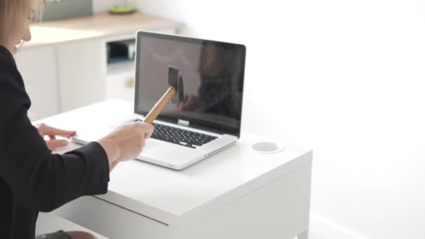 A woman threatens a broken laptop with a hammer — Stock Video