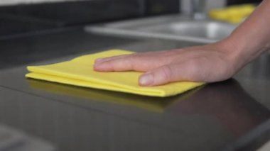 Yakın plan, yapay taştan yapılmış mutfak tezgahlarındaki tozu sil. Ev temizliği