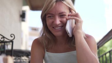 Bir kadın bir kafede cep telefonuyla konuşuyor..