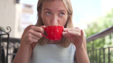 Yakın çekim, yavaş çekim. Bir bayan turist Antalya 'da bir kafede kahve içiyor..